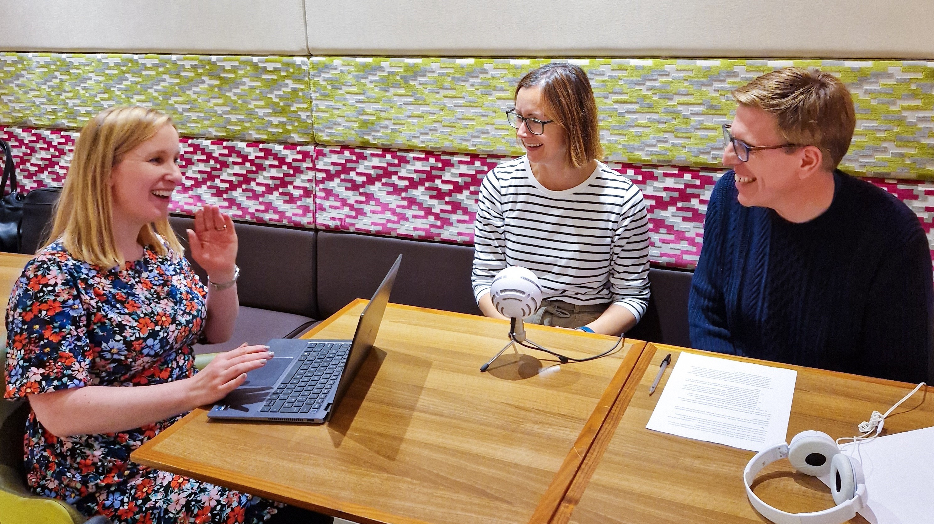 Regular podcast hosts Amy, Jess and Nigel recording a podcast in an office